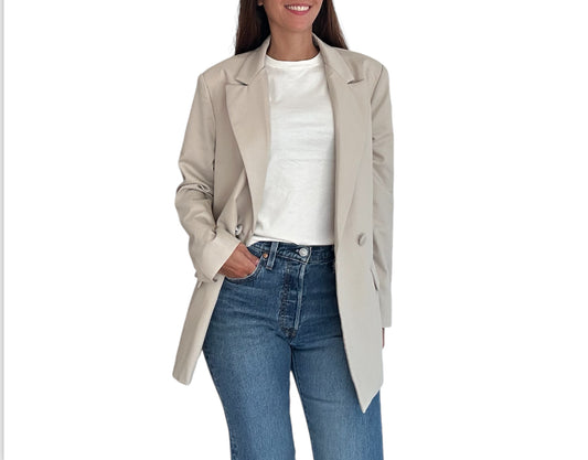 Ce blazer beige clair légèrement oversize se distingue par son élégance minimaliste et sa coupe ajustée qui flatte la silhouette.

Doté d'une fermeture croisée à deux boutons, il incarne parfaitement le style intemporel et raffiné. Les poches à rabat apportent une touche de praticité tout en soulignant l'esthétique épurée du vêtement. Le col à revers classiques et le tissu de haute qualité garantissent un confort optimal et une allure sophistiquée en toutes circonstances.