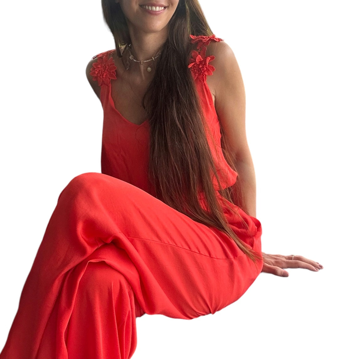 Découvrez notre combinaison fluide d'un orange éclatant, conçue pour allier confort et élégance. Dotée d'un buste légèrement blousant et de bretelles ornées de délicates fleurs, elle met en valeur votre silhouette avec une touche féminine raffinée. Son tissu léger, doublé jusqu'aux cuisses pour une opacité parfaite et une sensation de douceur sur la peau, fait de cette pièce le choix idéal pour une allure moderne et qui se distingue des autres styles.