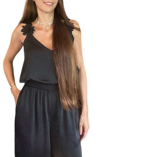 Découvrez notre combinaison fluide noire Anouck, conçue pour allier confort et élégance. Dotée d'un buste légèrement blousant et de bretelles ornées de délicates fleurs, elle met en valeur votre silhouette avec une touche féminine raffinée. Son tissu léger, doublé jusqu'aux cuisses pour une opacité parfaite et une sensation de douceur sur la peau, fait de cette pièce le choix idéal pour une allure moderne et qui se distingue des autres styles. 100% polyester. Doublure : 100% polyester