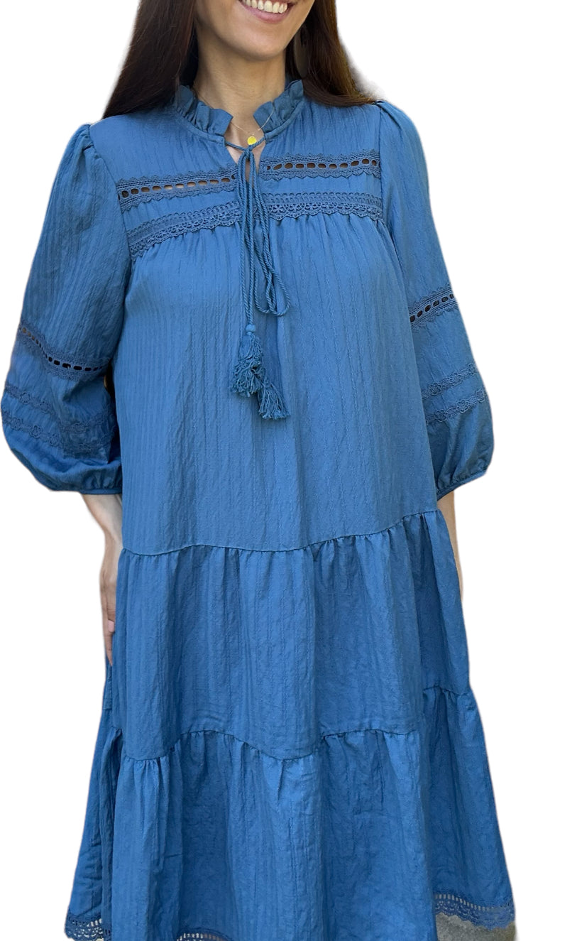 Robe d'été légère Daniella, élégante beige doublée avec des détails en dentelle et des broderies délicates. Cette robe à manches trois-quarts présente une encolure à cordon avec des pompons, ajoutant une touche bohème et décontractée.
La coupe ample et fluide est parfaite pour les journées chaudes, offrant confort et style. La robe est ornée de plusieurs volants, apportant du volume et du mouvement à chaque pas. 