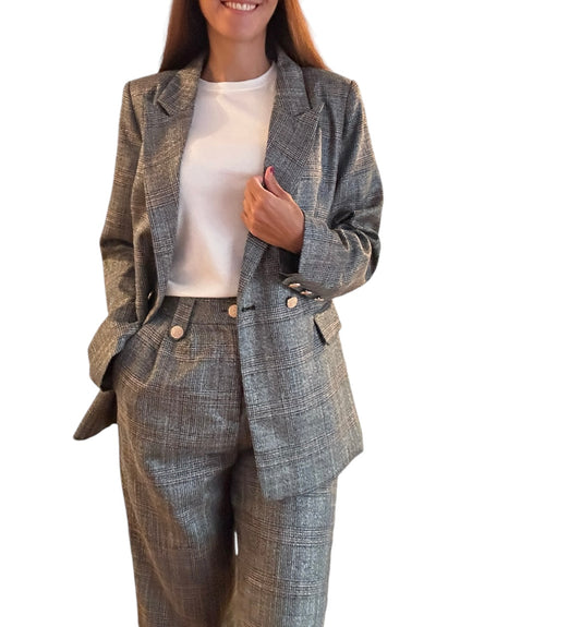 Affirmer votre style avec cet ensemble tailleur gris à carreaux, confectionné dans un tissu légèrement satiné et composé de coton. Son pantalon large et sa veste légèrement ample permettent de camoufler discrètement certaines imperfections tout en conservant une allure chic.&nbsp;Sa coupe généreuse offre une alternative stylée et décontractée, parfaite pour exprimer votre individualité avec aisance.

Le modèle mesure 1m69 et porte une taille S.