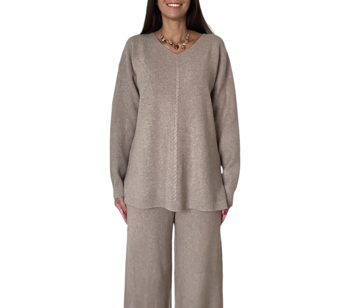 Cet ensemble cosy-chic est composé d'un pull ample à col en V et d'un pantalon large, tous deux confectionnés dans une matière de très bonne qualité, douce et confortable de couleur beige taupe.

Le pull, avec sa coupe décontractée et ses manches longues, offre un confort optimal tout en conservant une allure soignée. 